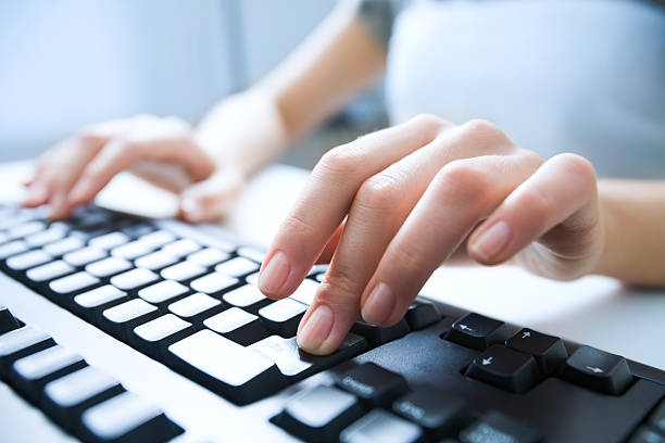 Close-up of female hand pressing enter key to start the system